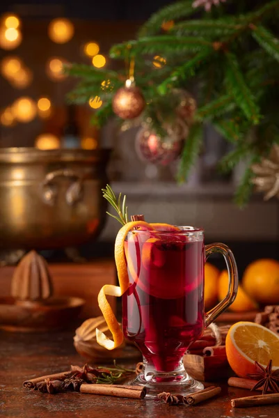Mulled wine with citrus, cinnamon, anise, and rosemary. Christmas mulled wine with spices, citrus, and vintage kitchen utensils.