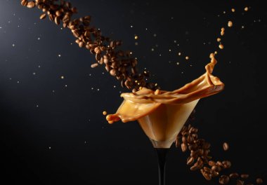 Espresso Martini, su sıçraması ve siyah arka planda kahve çekirdekleri. Boşluğu kopyala.