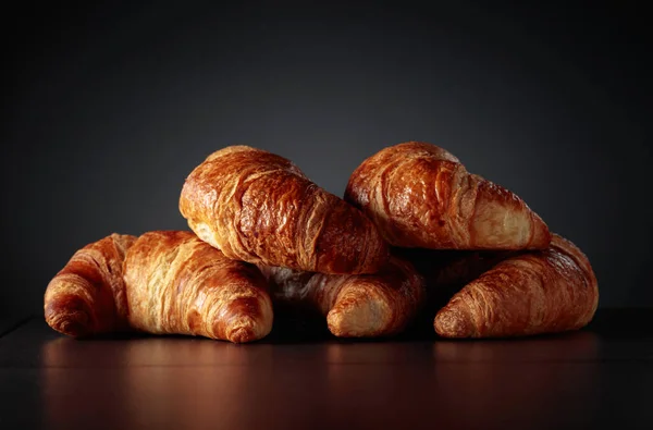 Freshly baked croissants on a black ceramic table. Traditional French kitchen.