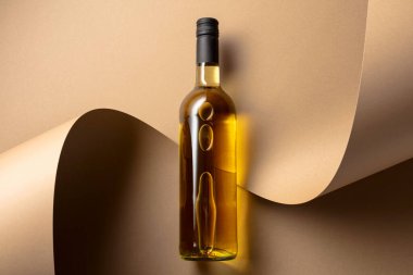 Bej arka planda bir şişe beyaz şarap. Üst Manzara. Boşluğu kopyala.