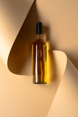 Bej arka planda bir şişe beyaz şarap. Üst Manzara. Boşluğu kopyala.