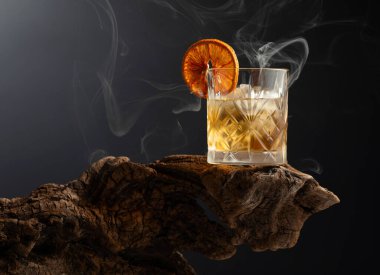 Eski usul buzlu ve kurutulmuş portakal dilimli rom kokteyli eski ahşap bir çıkmazda. Boşluğu kopyala.