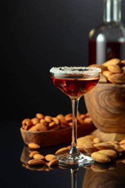 Siyah arka planda badem fıstığı olan güçlü alkolik İtalyan liklerinden Amaretto. Boşluğu kopyala.