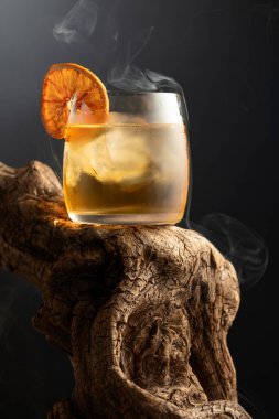 Eski usul buzlu ve kurutulmuş portakal dilimli rom kokteyli eski ahşap bir çıkmazda. Boşluğu kopyala.