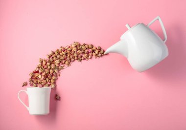 Pembe arka planda kurumuş gül goncaları. Bitkisel tıp temasının kavramsal görüntüsü. Kopyalama alanı olan üst görünüm.