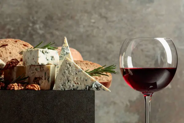 Blue cheese and red wine. Cheese with walnuts, bread, and rosemary. Copy space.