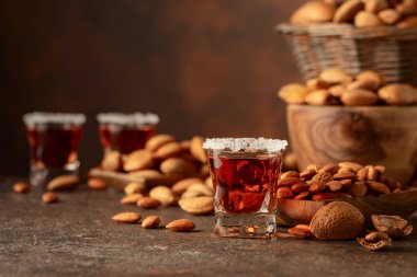 Alkolik İtalyan likörü Amaretto. Şarap masasında badem fıstığı var. Boşluğu kopyala.