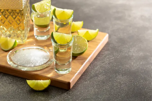 Gold Tequila Mit Meersalz Und Limettenscheiben Auf Einem Schneidebrett — Stockfoto