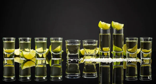 Tequila Shots Met Limoenschijfjes Zout Een Zwarte Reflecterende Achtergrond Kopieerruimte — Stockfoto