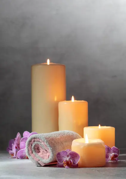Towels, orchid flowers, and burning candles. Spa concept with copy space.