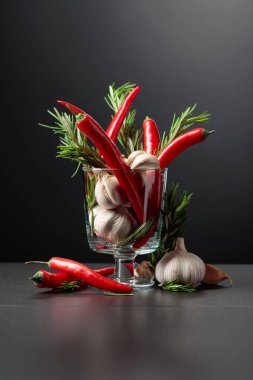 Kırmızı kırmızı biber, sarımsak ve biberiye siyah arka planda. Boşluğu kopyala..