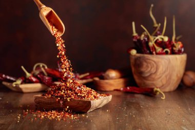 Biberler ahşap bir tabağa dökülür. Eski ahşap bir masada kırmızı biber ve kırmızı biber..