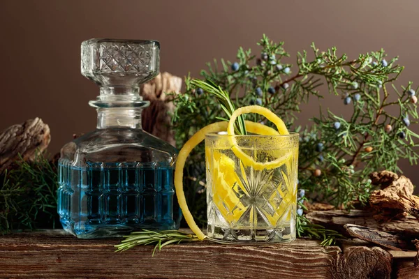 レモン ローズマリーを入れたカクテル トニック 古い板の上にジュニパーの枝やスナックとさわやかな飲み物 — ストック写真