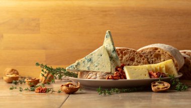 Mutfak masasında peynir, ekmek, ceviz ve kekik. Boşluğu kopyala.