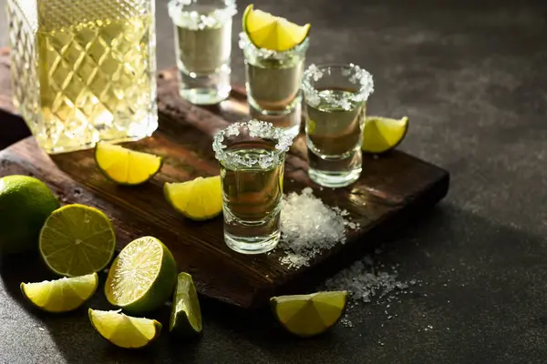 Gold Tequila Mit Meersalz Und Limettenscheiben Auf Einem Alten Schneidebrett — Stockfoto