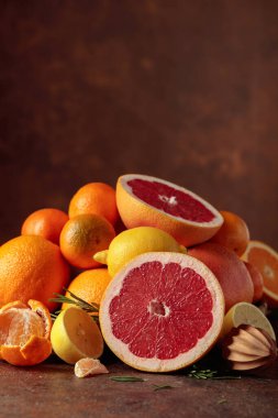 Eski kahverengi bir masanın üzerinde turunçgil meyveleri. Sunuma portakal, greyfurt, limon ve mandalina katılıyor. Boşluğu kopyala.