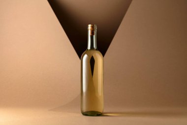 Bottle of white wine on a beige background. Copy space.