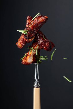 Izgara domuz göbeği ve çatallı biberiye. Siyah arkaplan.