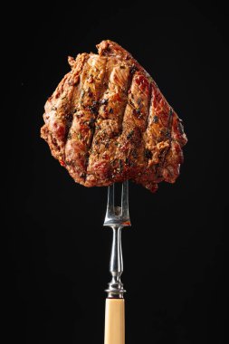 Siyah arka planda ızgara biftek. Çatallı biftek.. 