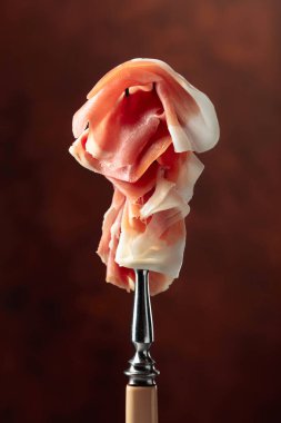 prosciutto çatal üzerinde ince dilim.