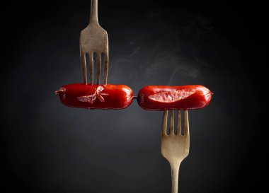 Çatalda ızgara sosis. Siyah arkaplan, boşluğu kopyala. 