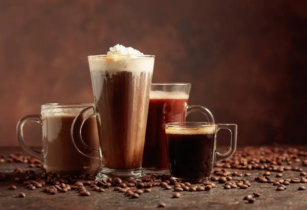 Kahverengi Arka Planda Dağınık Kahve Çekirdekleri Ile Çeşitli Kahve Çikolata — Stok fotoğraf