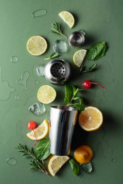 Kokteyl yapmak için malzemelerle karıştırıcı. Yeşil arka plan. Üst görünüm.