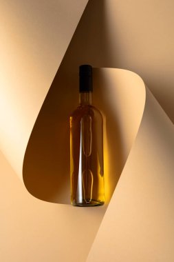 Bej arka planda bir şişe beyaz şarap. Üst Manzara. Boşluğu kopyala.