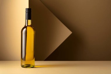 Bottle of white wine on a beige background. Copy space.