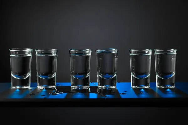 Αλκοολούχα Σφηνάκια Βότκας Δυνατό Ποτό Μικρά Ποτήρια Μαύρο Φόντο Μπλε — Φωτογραφία Αρχείου