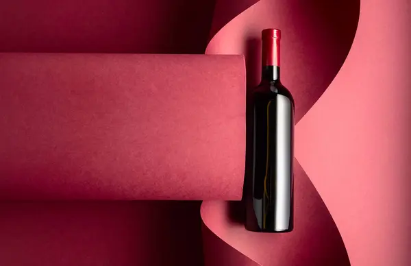 Fles Rode Wijn Een Rode Achtergrond Bovenaanzicht — Stockfoto