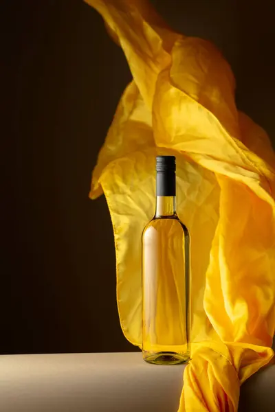 Botella Vino Blanco Aleteos Tela Amarilla Sobre Fondo Oscuro —  Fotos de Stock