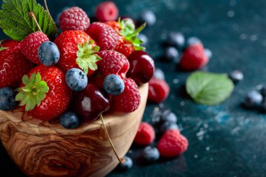 Çilek portre renkli çeşitli karışımı çilek, yaban mersini, ahududu ve tatlı kiraz Studio koyu arka plan üzerinde.