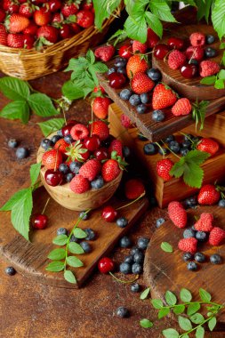 Yapraklı taze böğürtlen. Eski bir masada çilek, ahududu, yabanmersini ve tatlı kirazlar.. 