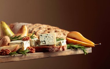 Mavi peynirli ve armutlu sandviç. Eski ahşap bir masa ekmeği, mavi peynir, armut, ceviz ve biberiye.