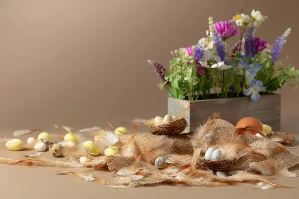 Paascompositie Met Eieren Veren Lentebloemen Een Beige Achtergrond Kopieerruimte — Stockfoto