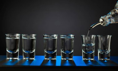 Alkolik votka kadehleri ya da küçük bardaklarda sert içkiler. Barmen sert ruhu bardaklara doldurur, servis ve içecekler hakkında konsept yapar. Boşluğu kopyala.