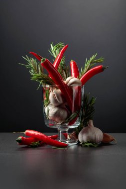 Kırmızı kırmızı biber, sarımsak ve biberiye siyah arka planda. Boşluğu kopyala..