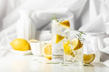 Yaz ferahlatıcı limonata ya da beyaz masada buzlu, biberiyeli ve limonlu alkollü kokteyl. Taze, sağlıklı, soğuk limon suyu. Buzlu ve limonlu su.