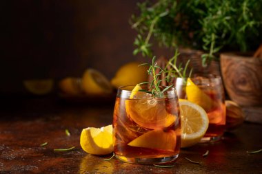 Buzlu çay veya eski kahverengi masada buzlu, biberiyeli ve limonlu alkollü kokteyl. Taze, sağlıklı, soğuk limon suyu. Buzlu ve limonlu çay..