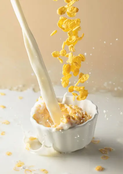セラミックプレートにミルクスプラッシュが付いている乾燥した蜂蜜のコーンフレーク 有機農場のミルクを使ったフレーク 朝食のための健康的な食事 ベジタリアン ビーガン料理の概念 — ストック写真