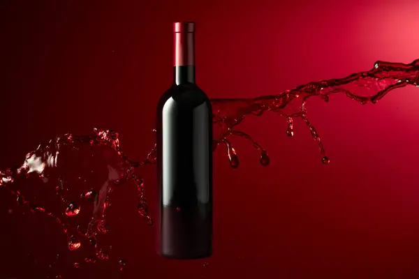 Butelka Czerwonego Wina Plusk Ciemnoczerwonym Tle Przestrzeń Kopiowania — Zdjęcie stockowe
