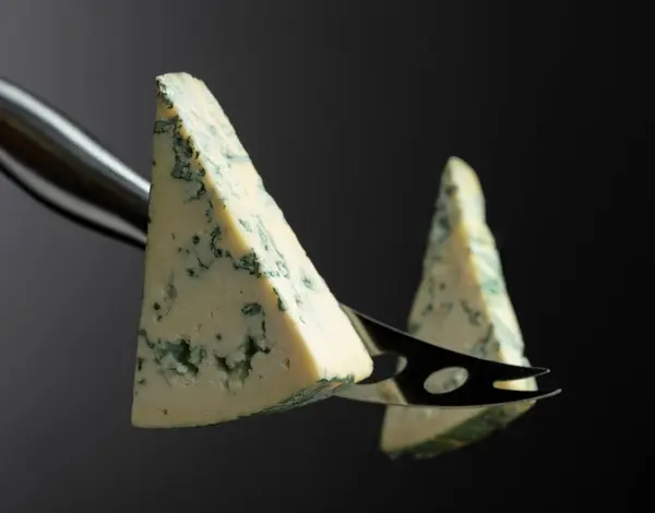 Ένα Μαχαίρι Τυριού Κόβει Ένα Κομμάτι Μπλε Τυρί Στη Μέση Εικόνα Αρχείου