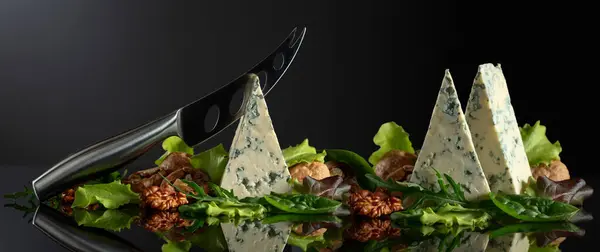 Blauschimmelkäse Mit Messer Walnüssen Und Frischem Grün Auf Schwarzem Hintergrund Stockbild