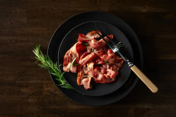 Rostade Baconskivor Med Rosmarin Ett Gammalt Träbord Uppfattat Utrymme Ovanifrån — Stockfoto