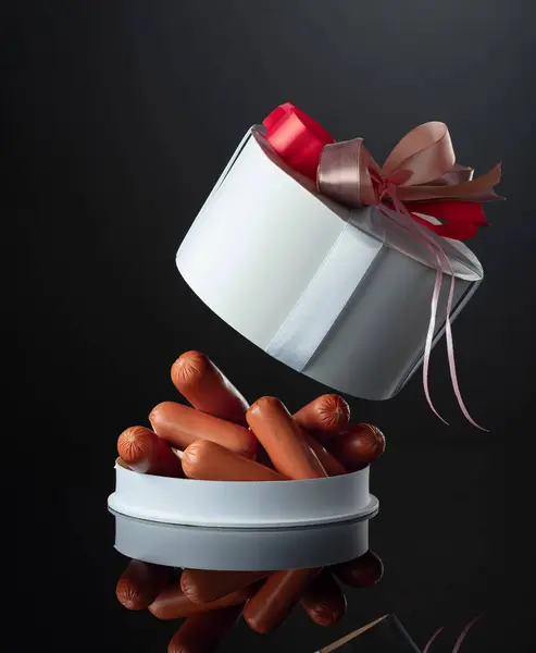 Geöffnete Geschenkbox Mit Würstchen Auf Schwarzem Reflektierendem Hintergrund — Stockfoto
