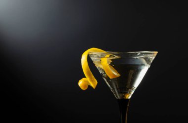 Siyah arka planda limon kabuğu olan klasik sek martini kokteyli. Metnin için boş yer.