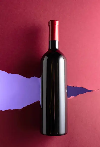 赤ワインのボトルは濃い赤色の背景 トップビュー ロイヤリティフリーのストック画像