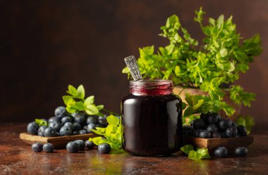 Kahverengi arka planda yabanmersini reçeli ve taze böğürtlen.