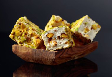 Siyah yansıtıcı arka planda ahşap bir kapta geleneksel Türk zevki.